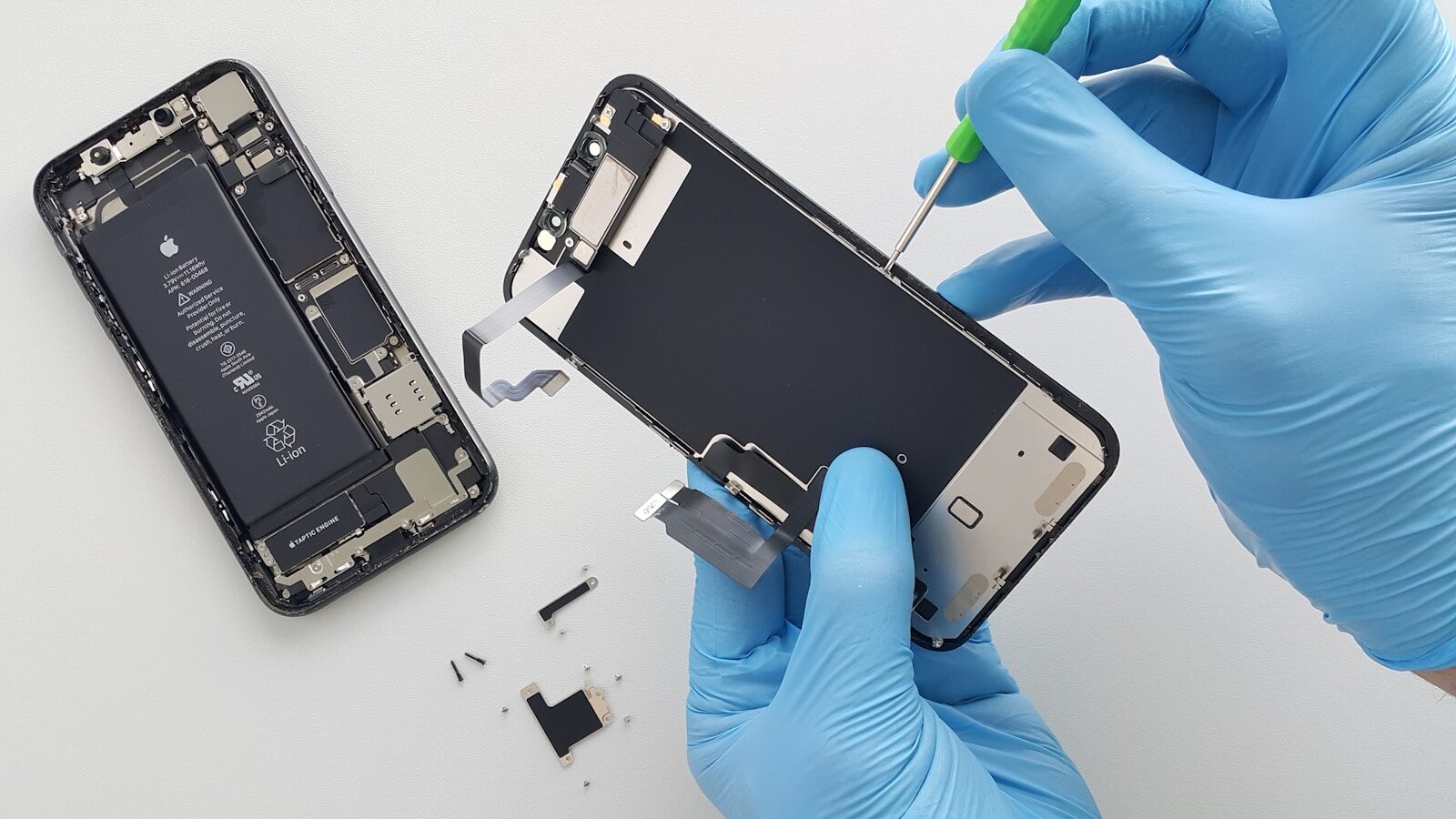 a person in blue gloves holding a cell phone